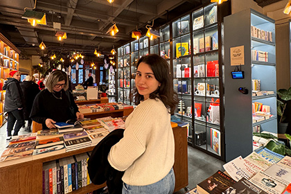 Charles Sturt University Sydney Melbourne student Sena standing in a bookshop, looking backwards towards camera