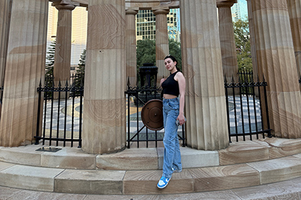 Charles Sturt Melbourne Student Sena standing in front of a monument with pillars