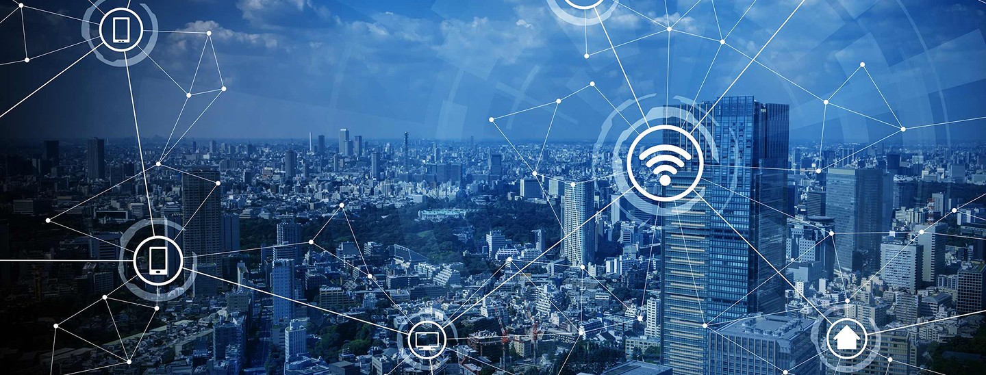 Graphic with a city skyline in the background and icons relating to the IT and technology laid over the image with a blue hue