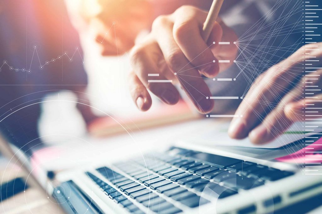 A photo of hands operating a laptop keyboard, with white graphics related to data analytics overlayed
