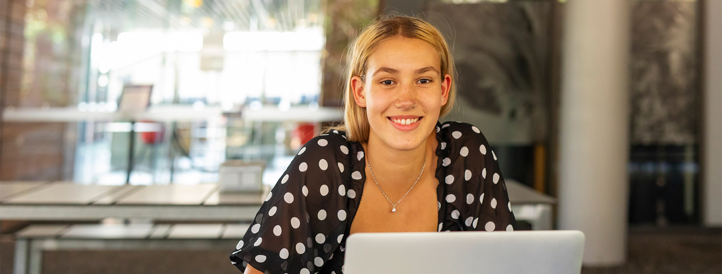 Australian student on laptop smiling