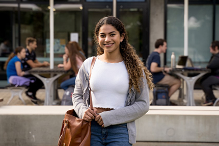 Female student facing camera smiling standing