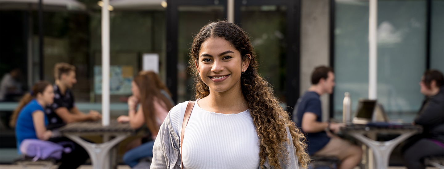 Female student standing outside smiling