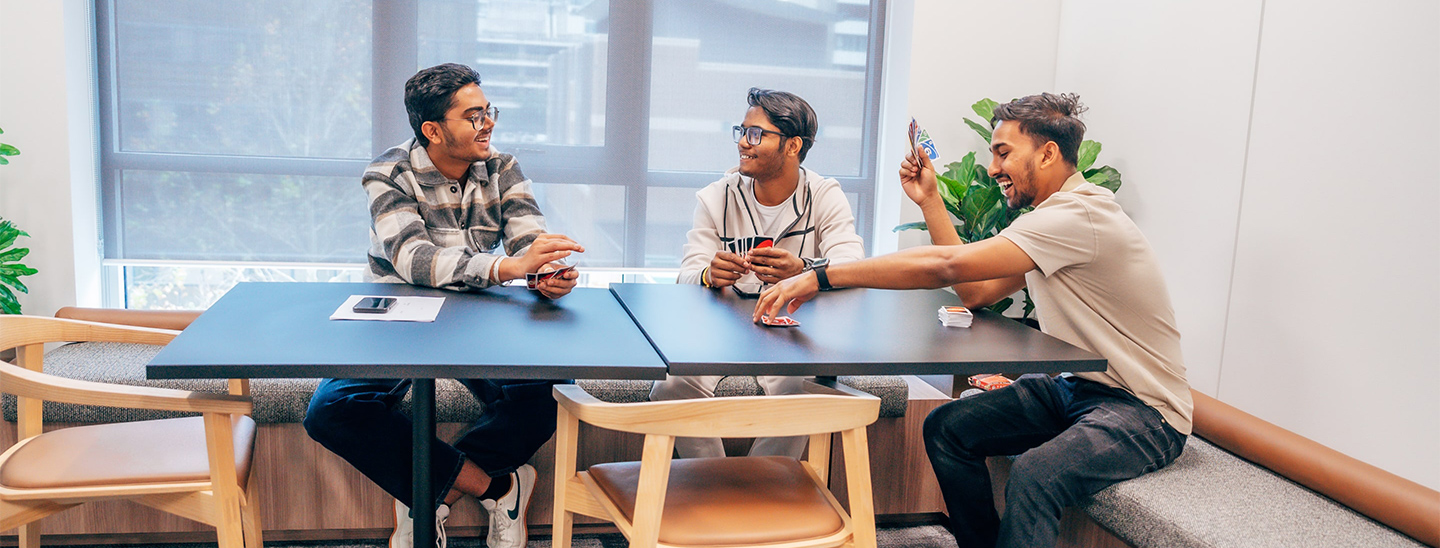 Male students playing uno happy