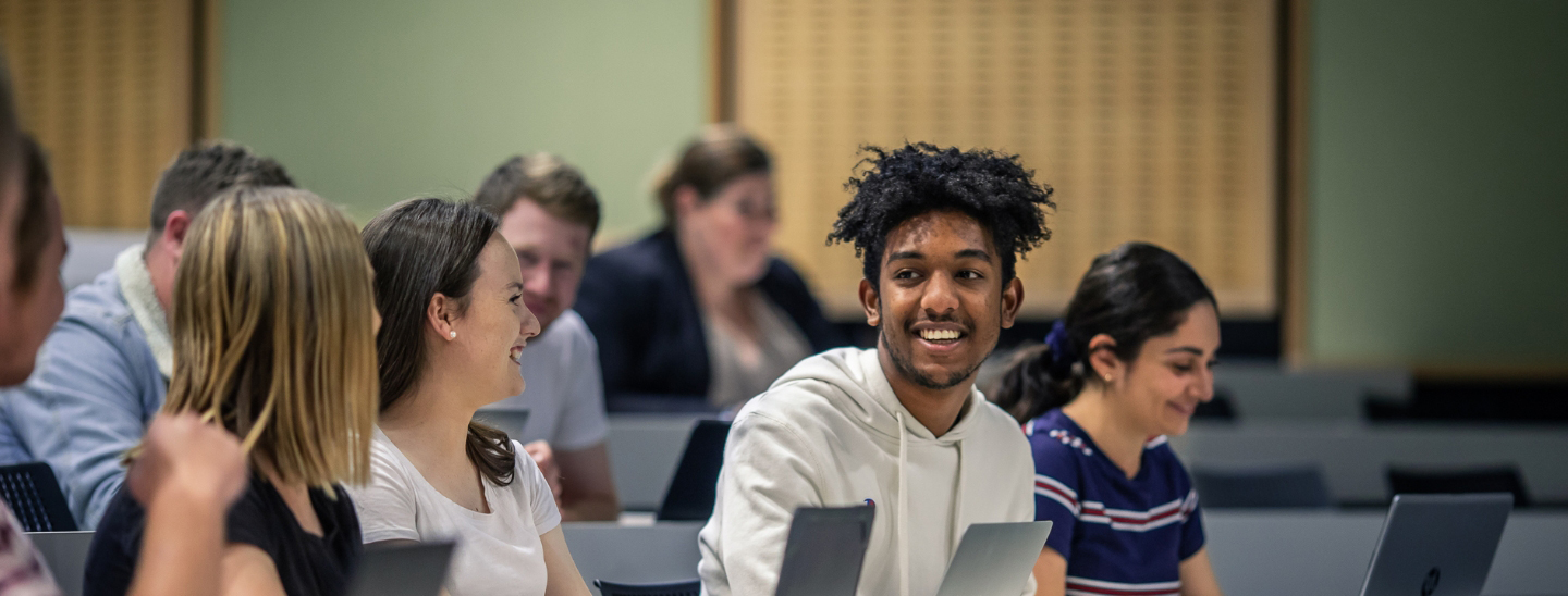 Students smiling on campus in lecture hall