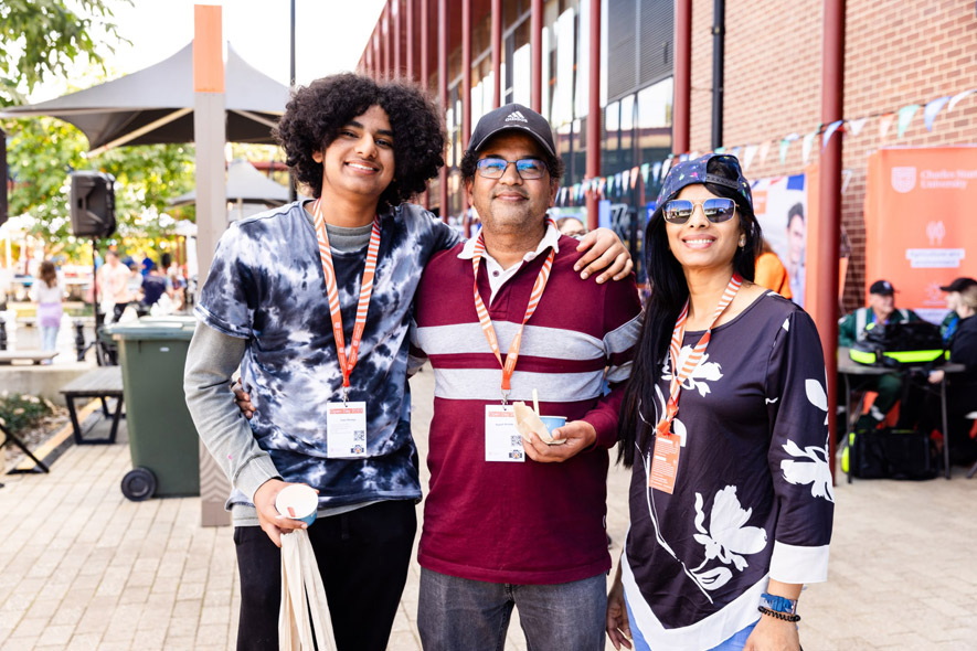 Three students standing togethera t open day event